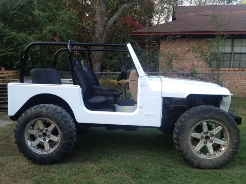 2000 Jeep TJ - This white Jeep is missing its front fenders and grille, showing its engine bay.