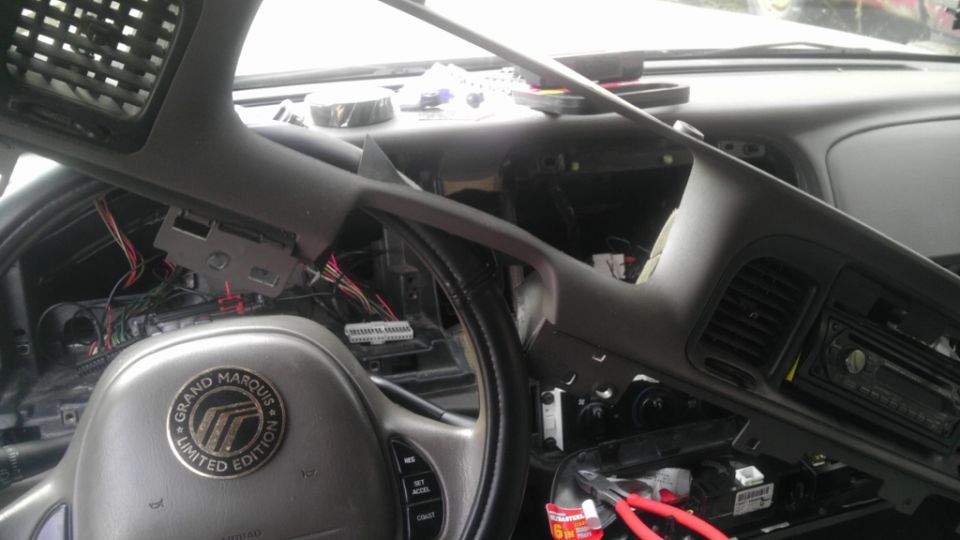 Interior of a 2000 Mercury Grand Marquis with dashboard disassembled, showing wiring and steering wheel with 'Grand Marquis Limited Edition' badge