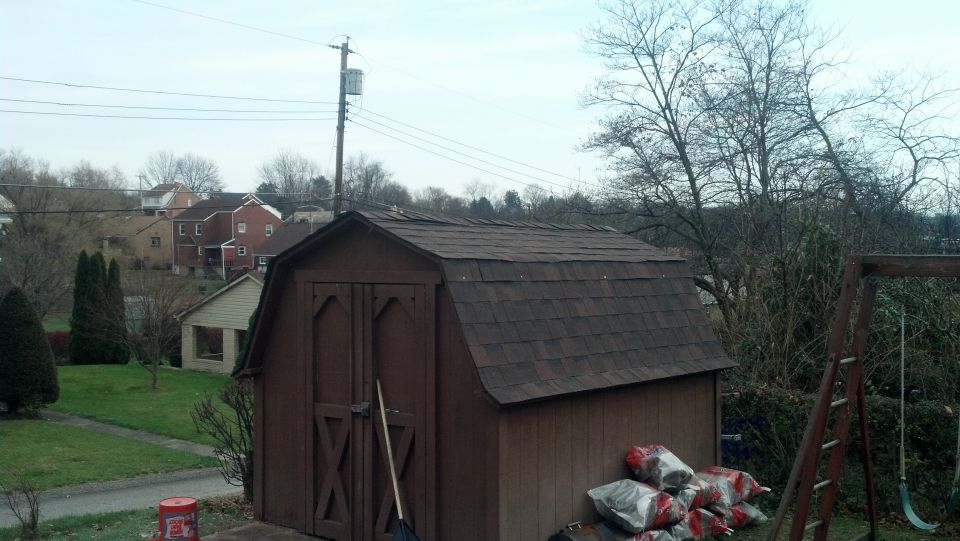 Brown shed with a gambrel roof and double doors