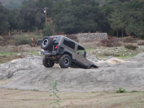 1978 Ford Bronco - A Jeep Wrangler navigates challenging rocky terrain, demonstrating its off-road capabilities.