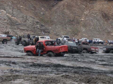 1978 Ford Bronco - Several trucks are stuck in deep mud during an off-road event.