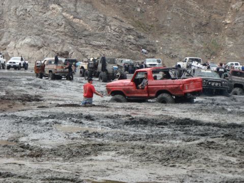 1978 Ford Bronco - Several off-road vehicles are stuck in deep mud during an event.