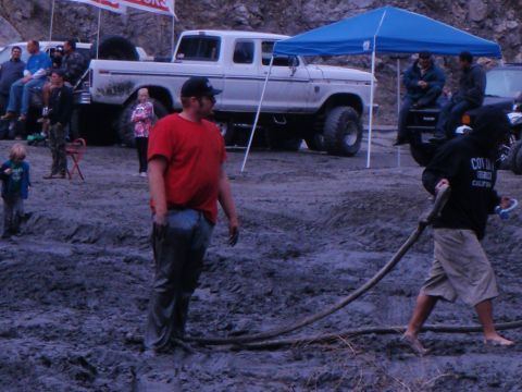 1978 Ford Bronco - Off-road vehicles and people gathered in a muddy area, possibly for an event.