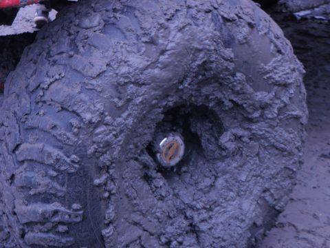 1978 Ford Bronco - A close-up view of a heavily mud-caked tire and wheel hub.