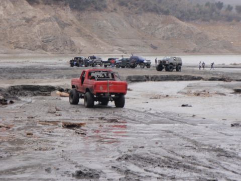 1978 Ford Bronco - Modified 1978 Ford Bronco navigating a muddy terrain with other vehicles present.