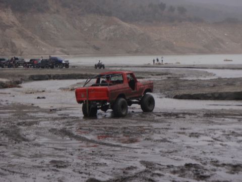 1978 Ford Bronco - Modified 1978 Ford Bronco navigating muddy terrain with other off-road vehicles present.