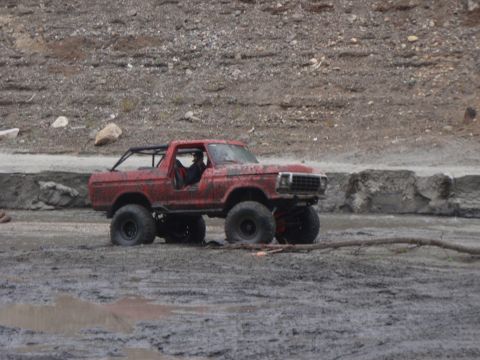 1978 Ford Bronco - Modified 1978 Ford Bronco with a roll cage navigates a muddy off-road course.