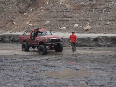 1978 Ford Bronco - Modified 1978 Ford Bronco navigating a muddy terrain with a person cleaning the windshield.