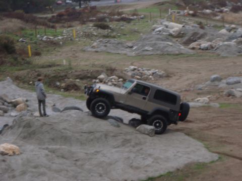 1978 Ford Bronco - A Jeep Wrangler navigates a challenging rocky obstacle during an off-road excursion.