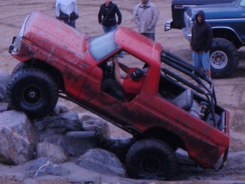 1978 Ford Bronco - A red 1978 Ford Bronco navigates a rocky obstacle course with a roll cage installed.