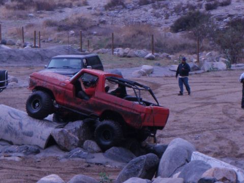 1978 Ford Bronco - A red Bronco navigates a rocky obstacle course with another vehicle in the background.