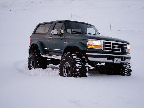 1996 Ford Bronco - This 1996 Ford Bronco, equipped with large off-road tires, navigates a snowy landscape.
