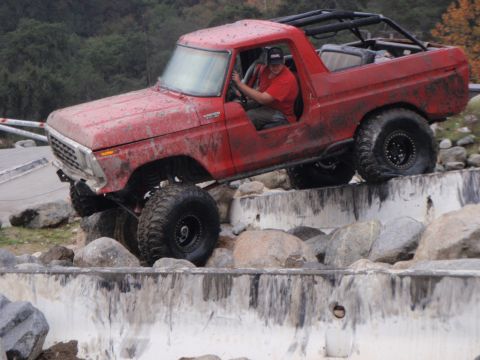 1978 Ford Bronco - A red 1978 Ford Bronco navigates a challenging rock obstacle course.