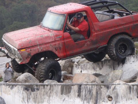 1978 Ford Bronco - A red 1978 Ford Bronco navigates a challenging rocky obstacle course.