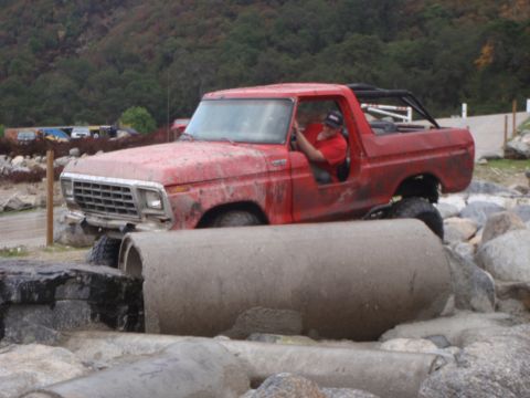 1978 Ford Bronco - This red 1978 Ford Bronco is shown navigating a challenging off-road course with large concrete pipes.
