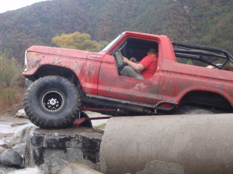 1978 Ford Bronco - This 1978 Ford Bronco is shown off-roading over large rocks and concrete pipes.