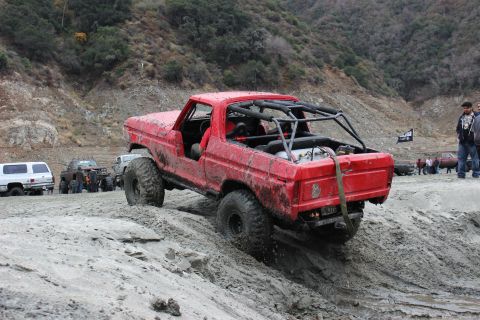 1978 Ford Bronco - A modified 1978 Ford Bronco navigates a challenging off-road course with other vehicles present.