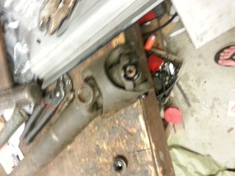 1978 Ford Bronco - Close-up of a driveshaft component resting on a workbench, surrounded by various tools.