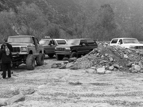 1978 Ford Bronco - A group of modified trucks and SUVs are gathered in a rocky, outdoor area.
