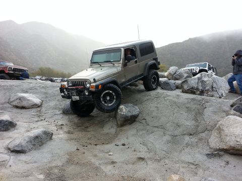 1978 Ford Bronco - Multiple Jeeps navigate a rocky off-road course in a mountainous area.