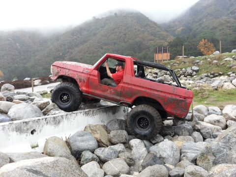 1978 Ford Bronco - A red 1978 Ford Bronco is shown navigating a rocky obstacle course.