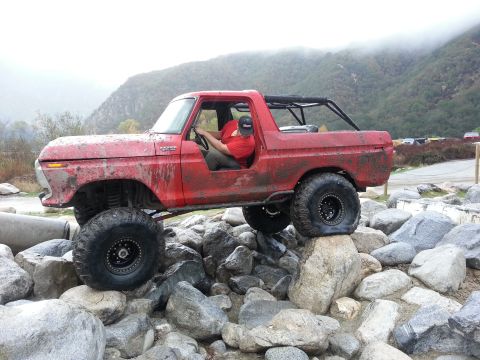 1978 Ford Bronco - A red 1978 Ford Bronco navigates a rocky obstacle course.