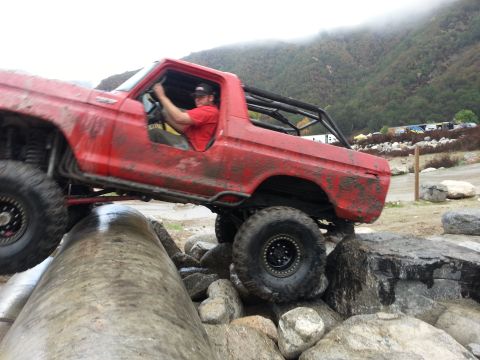 1978 Ford Bronco - A red 1978 Ford Bronco navigates a challenging rocky terrain during an off-road excursion.