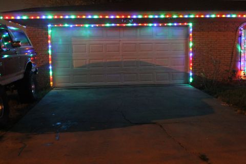 1990 Ford Bronco - A 1990 Ford Bronco is parked in front of a garage adorned with colorful Christmas lights.