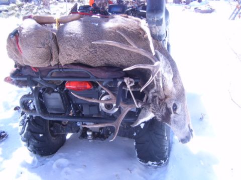 1994 Jeep Cherokee - An ATV is loaded with a deer carcass and hunting gear, parked in the snow.