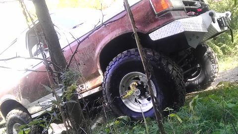 1989 Ford Bronco - This red Ford Bronco appears to be from the late 1980s, with a custom front bumper and off-road tires.