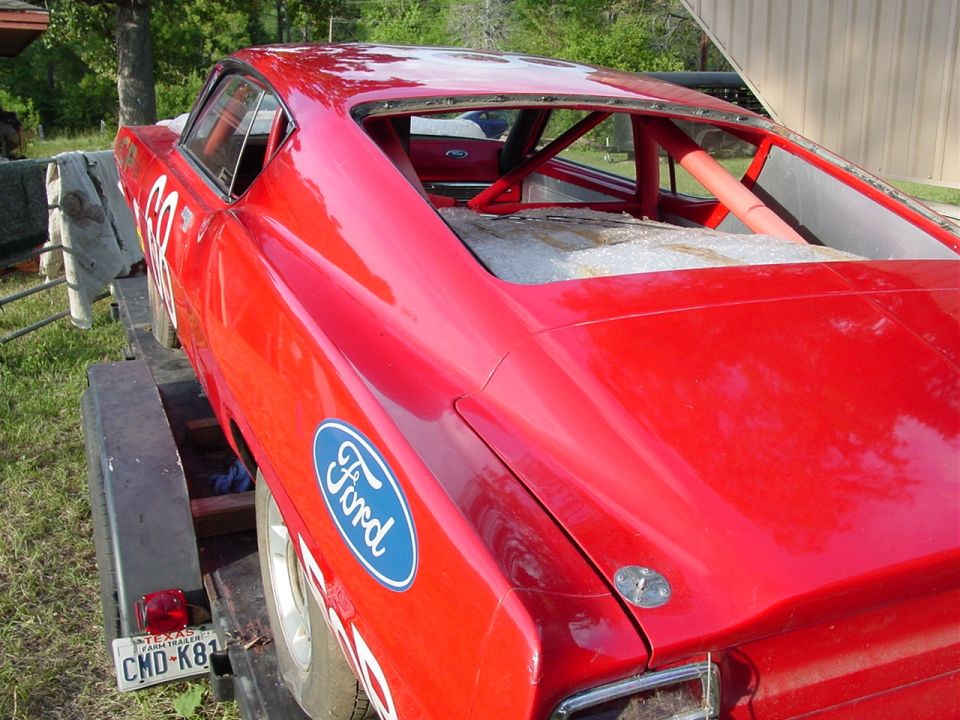 1968 Ford Torino race car with roll cage, on a trailer. Ford oval logo on fender
