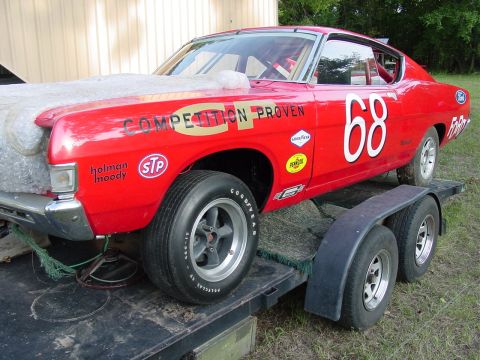 1968 Ford Torino - A red 1968 Ford Torino race car, identified by its body style and decals, is loaded onto a trailer.
