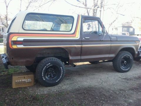 1979 Ford Bronco - This Ford Bronco features a distinctive stripe package on its side. A box is placed under the rear tire.
