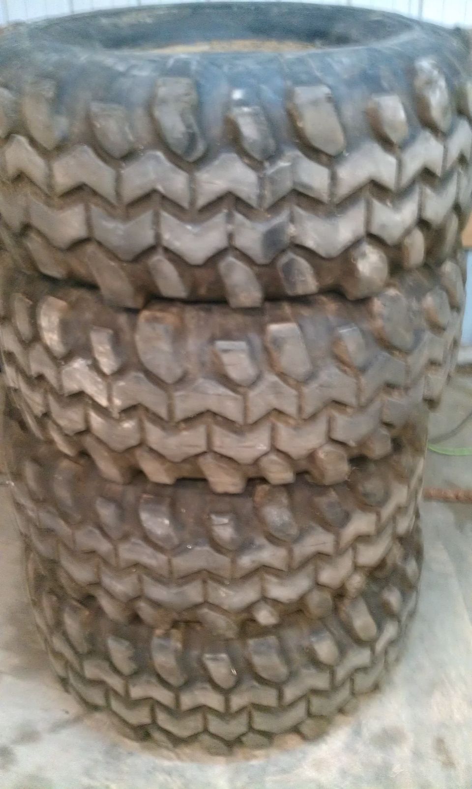 Stack of four chunky off-road tires with aggressive tread patterns