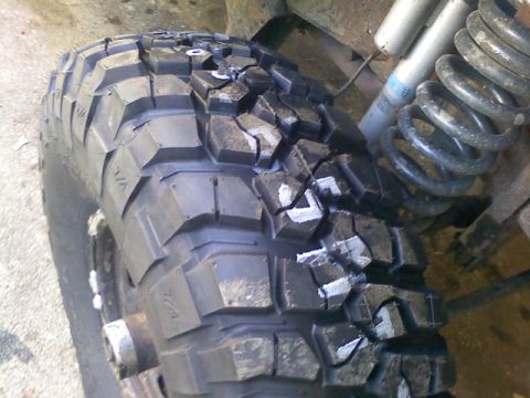 1994 Ford F-150 - Detail of an off-road tire and suspension components, likely from a truck or SUV.