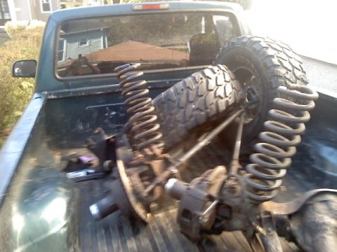 1994 Ford F-150 - Suspension parts are loaded into the bed of a pickup truck.