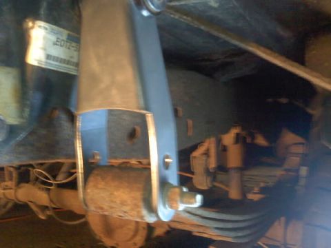 1994 Ford F-150 - Undercarriage view of a truck's rear suspension system, focusing on the shock absorber and axle assembly.