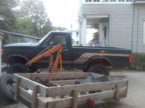 1994 Ford F-150 - A dark blue pickup truck is parked next to a house, with a wooden crate of parts in front of it.