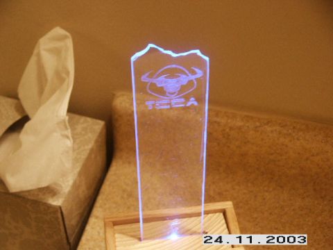 1998 Mercury Sable - An illuminated trophy with a bull logo and the word 'TECA' is displayed on a wooden base next to a tissue box.