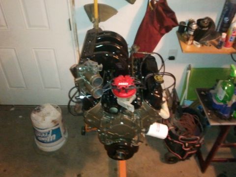 1990 Ford Bronco - Engine assembly sits on a stand in a garage, ready for installation or work.