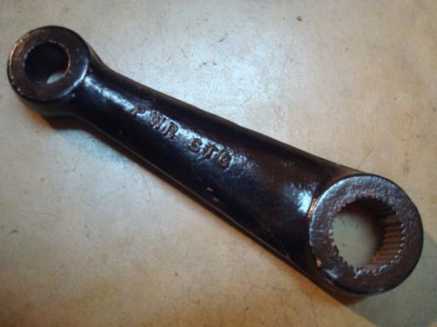 1995 Ford Bronco - This is a steering arm part, likely for power steering, with text stamped on it.