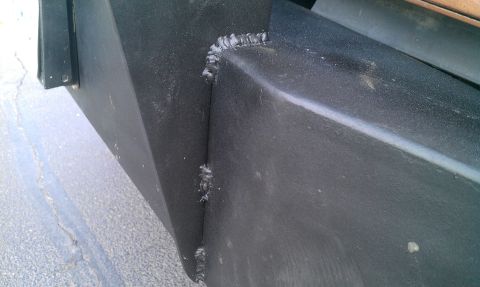 1987 Ford Bronco - Detail of welded seams on a black metal component, showing unfinished craftsmanship.