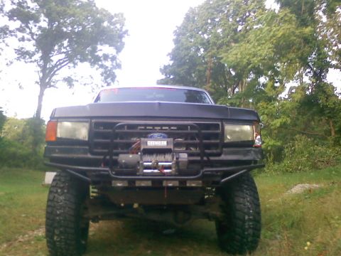 1994 Ford F-150 - Front view of a black Ford truck with a winch mounted on the custom bumper.
