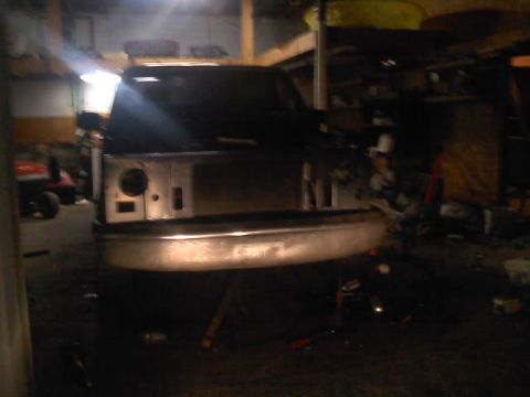1994 Ford F-150 - Front view of a truck undergoing repairs in a garage, with the grille removed.