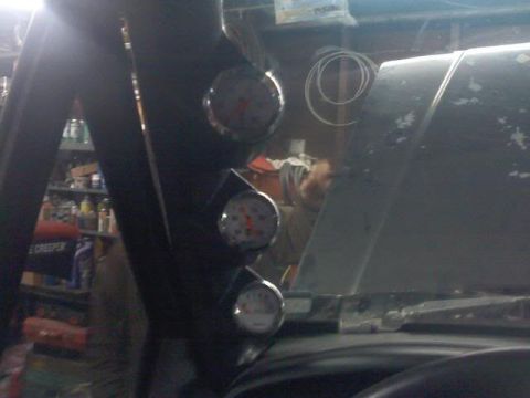 1994 Ford F-150 - Gauges are visible inside a vehicle, with a reflection on the hood.