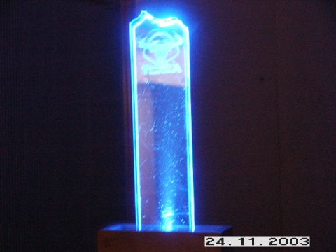 1998 Mercury Sable - A trophy with a blue illuminated logo and text is displayed on a wooden base.