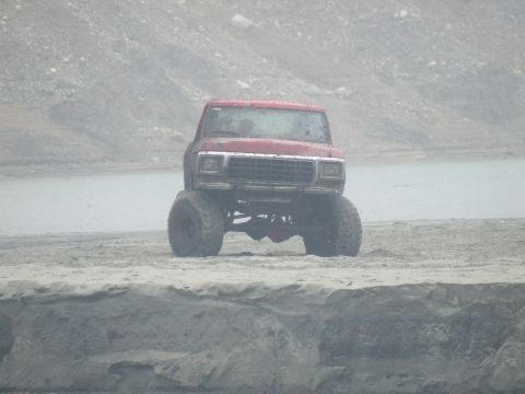 1978 Ford Bronco - A red 1978 Ford Bronco is shown from the front, a lifted suspension and oversized tires.