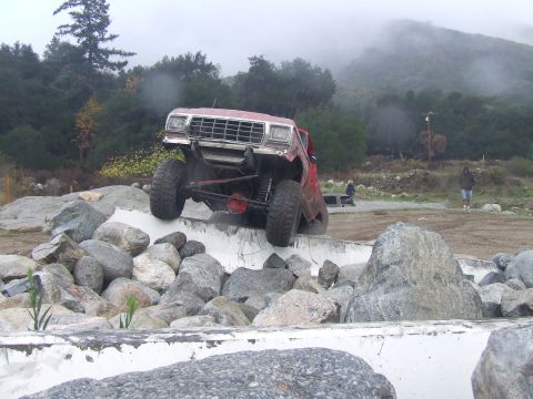 1978 Ford Bronco - A red 1978 Ford Bronco navigates a rocky obstacle course, demonstrating its off-road capabilities.