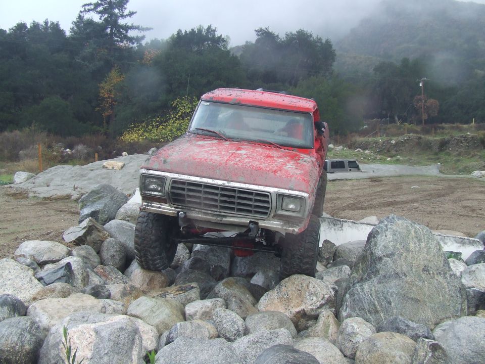 Red 1978 Ford Bronco navigating rocky terrain