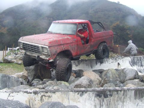 1978 Ford Bronco - A red 1978 Ford Bronco navigates a challenging rocky obstacle course.